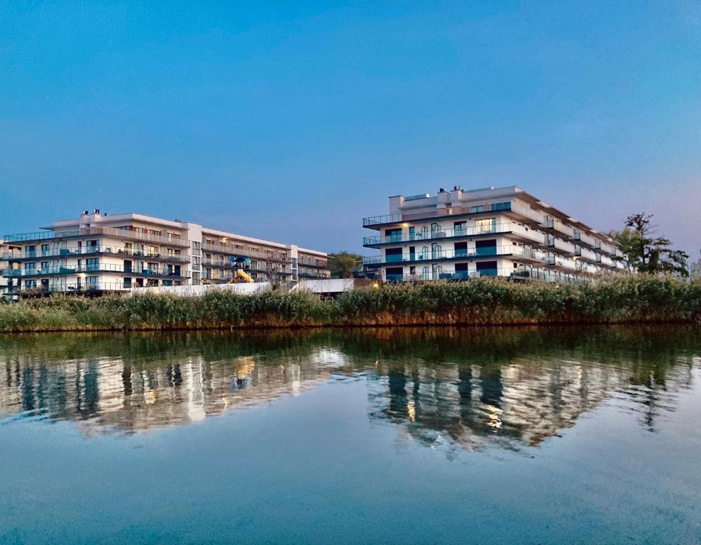 ParaSOL - Baltic Relax - Pool, Jacuzzi, Sauna في جيفنوف: مبنيين للشقق بجانب تجمع المياه