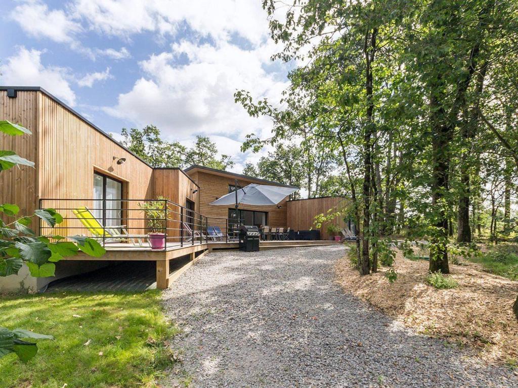 a house with a porch and a patio at Grande maison en bois avec parc, terrasse, jeux et équipements modernes entre Nantes et Pornic - FR-1-306-1051 in Port-Saint-Père