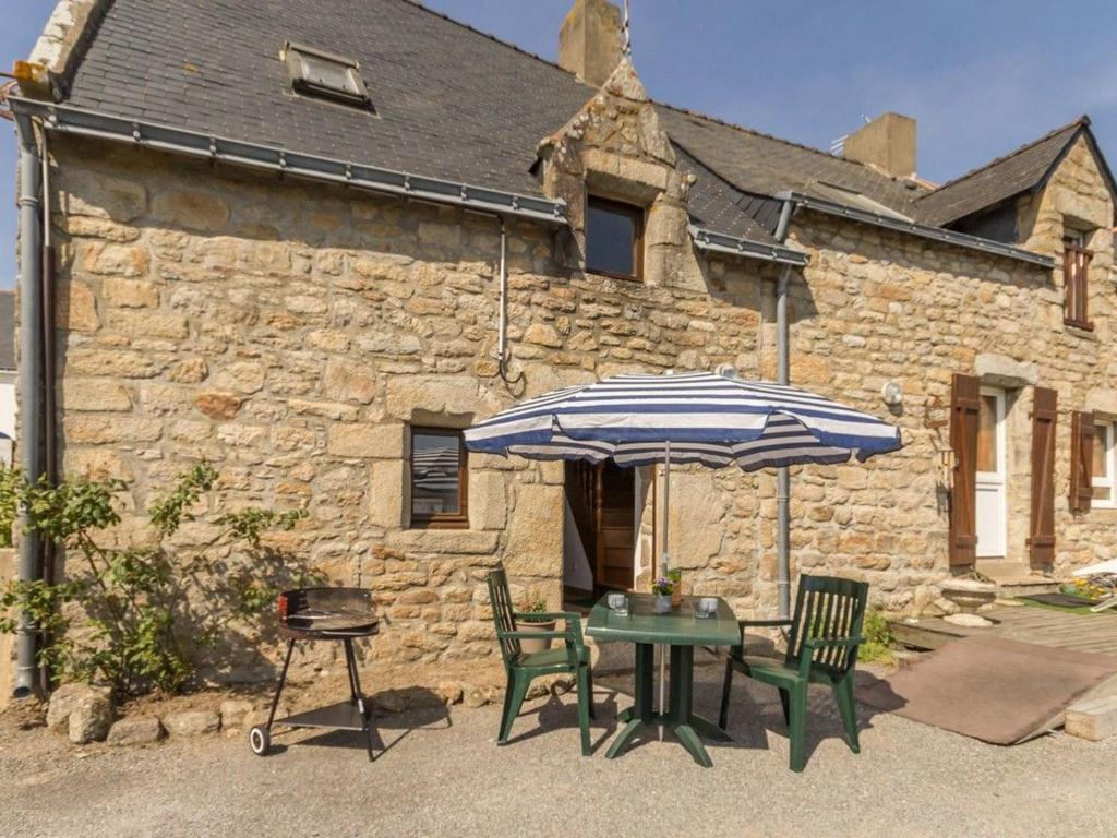 a table and chairs and an umbrella in front of a building at Charmante Maison Rénovée à 500m de la Mer avec Jardin, 2 Chambres, Parking Gratuit - FR-1-306-911 in Piriac-sur-Mer