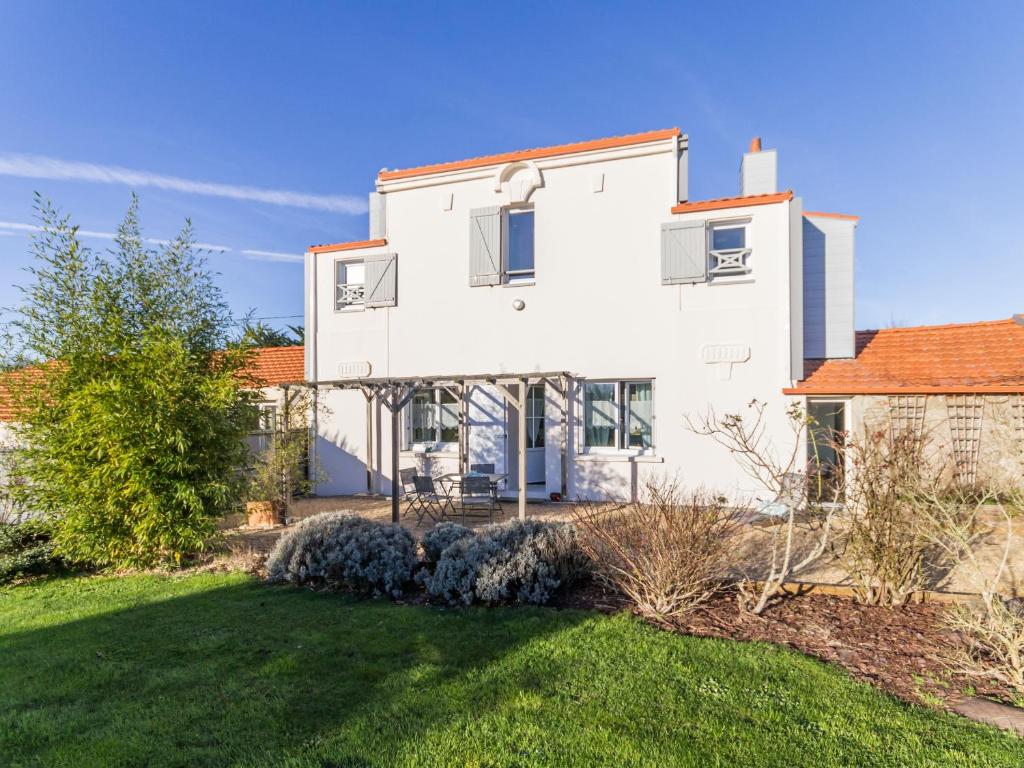 une grande maison blanche avec une cour dans l'établissement Gîte paisible proche de la mer avec jardin, WIFI, et équipements bébé - FR-1-306-1037, à Pornic