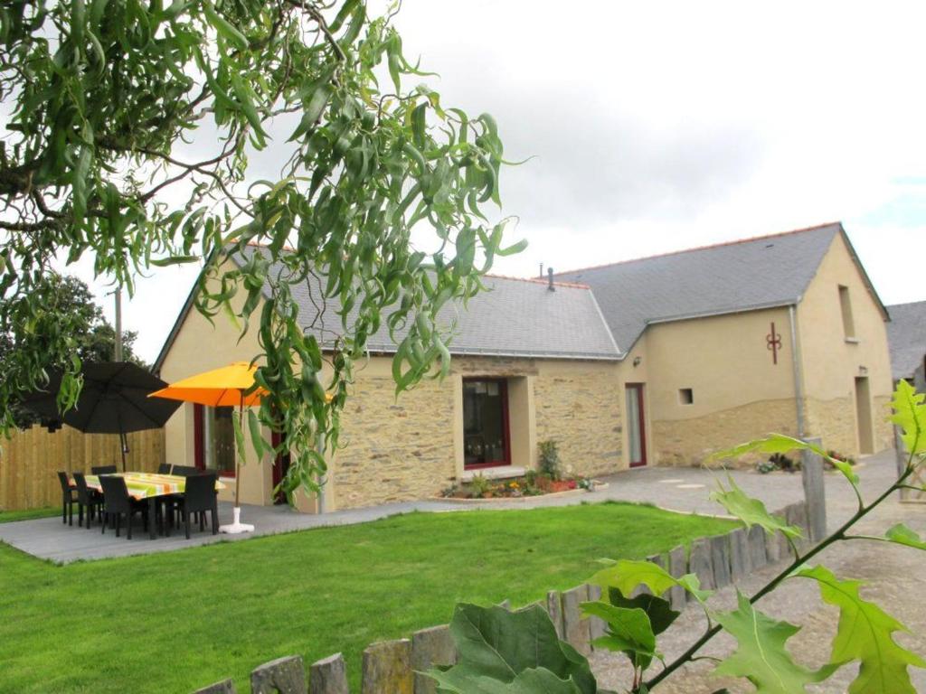 a house with a table and chairs in the yard at Gîte rénové avec jardin clos, proche Nantes, idéal famille, accessible PMR, wifi inclus - FR-1-306-1134 in Vay