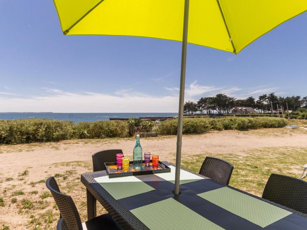 einen Tisch mit Sonnenschirm am Strand in der Unterkunft Appartements à Piriac-sur-Mer, plage, wifi, animaux acceptés - FR-1-306-1155 in Piriac-sur-Mer