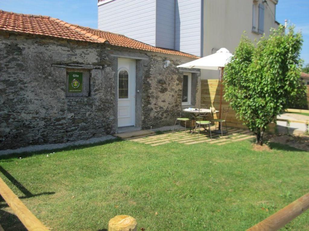 une petite maison en pierre avec une cour avec une table dans l'établissement Gîte tranquille à Pornic avec jardin privé, WiFi et garage vélos - FR-1-306-1058, à Pornic
