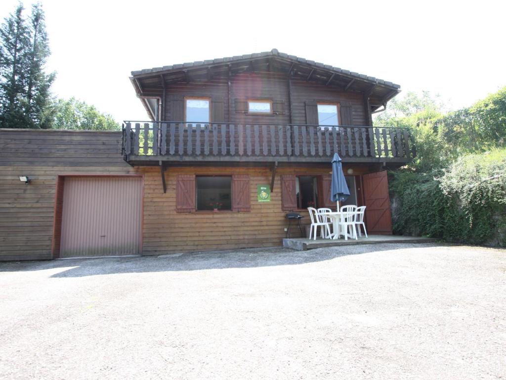 une maison avec une terrasse, une table et un parasol dans l'établissement Charmant Gîte en Montagne avec Terrasse et Garage, Proche La Bresse Ski et Sentiers Balises - FR-1-589-17, à Cornimont