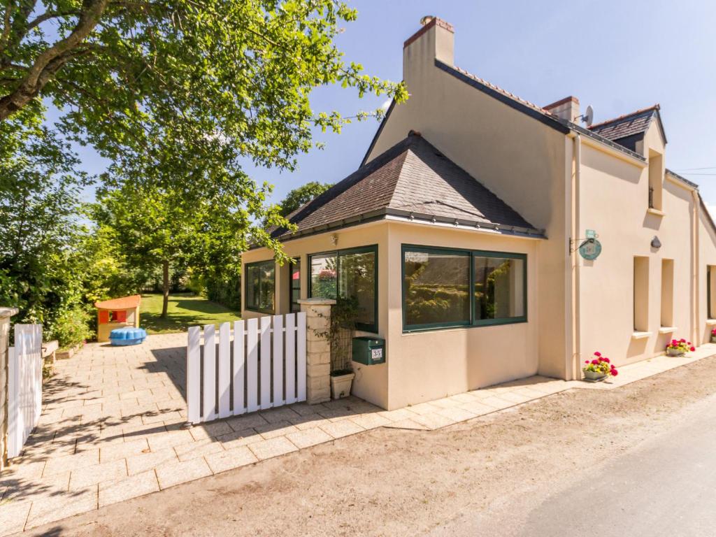 un cottage con una staccionata bianca e un vialetto d'accesso di Gîte familial près de Guérande avec jardin, terrasse, jeux pour enfants, et coin détente - FR-1-306-1095 a Sainte-Reine-de-Bretagne