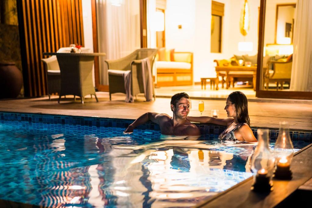 a man and a woman in a swimming pool at Anantara Peace Haven Tangalle Resort in Tangalle