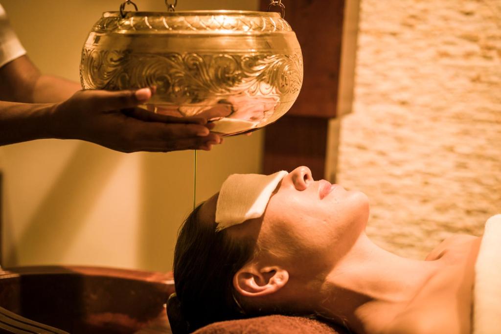 a man laying on the ground with his head under a trophy at Anantara Peace Haven Tangalle Resort in Tangalle