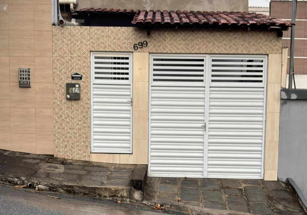 zwei weiße Garagentüren an der Seite eines Gebäudes in der Unterkunft Casa em Campina Grande PB in Campina Grande