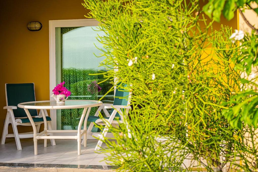 a table and chairs on a patio with a window at Bayview Condo in Saint Johnʼs