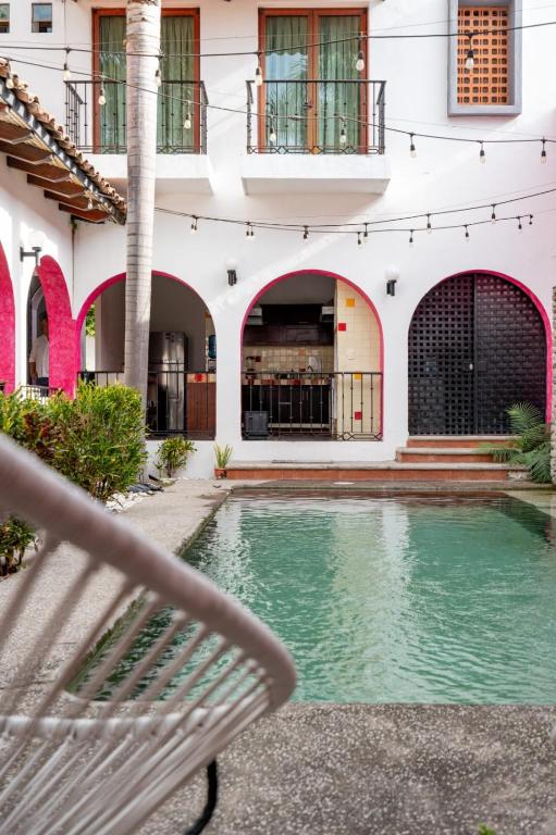 a bench in front of a building with a swimming pool at Los Suspiros Hotel Boutique & Spa in Comala