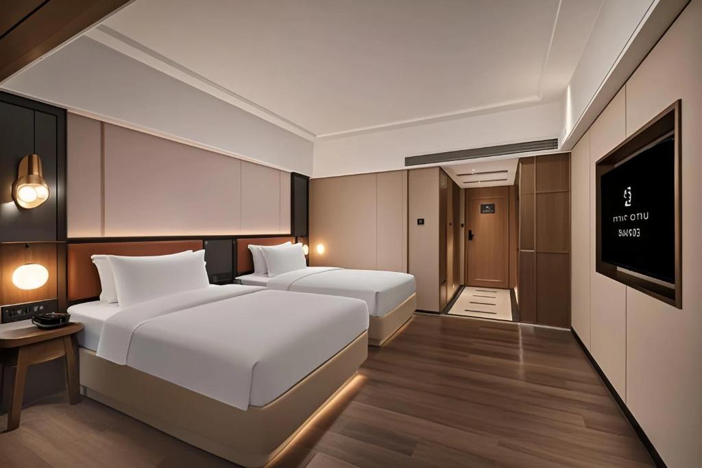 Postel nebo postele na pokoji v ubytování Mehood Lestie Hotel Dongguan Chang'an