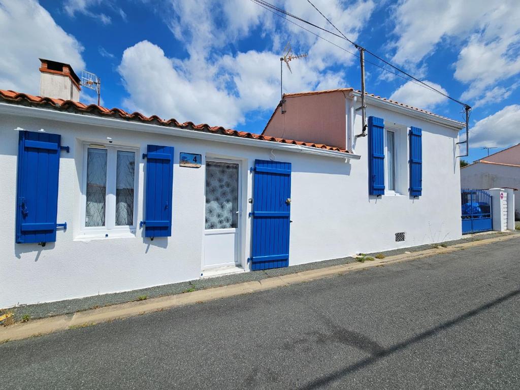 Maison blanche avec volets bleus dans une rue dans l'établissement Maison rénovée 6 pers proche centre - FR-1-476-236, à LʼAiguillon-sur-Mer