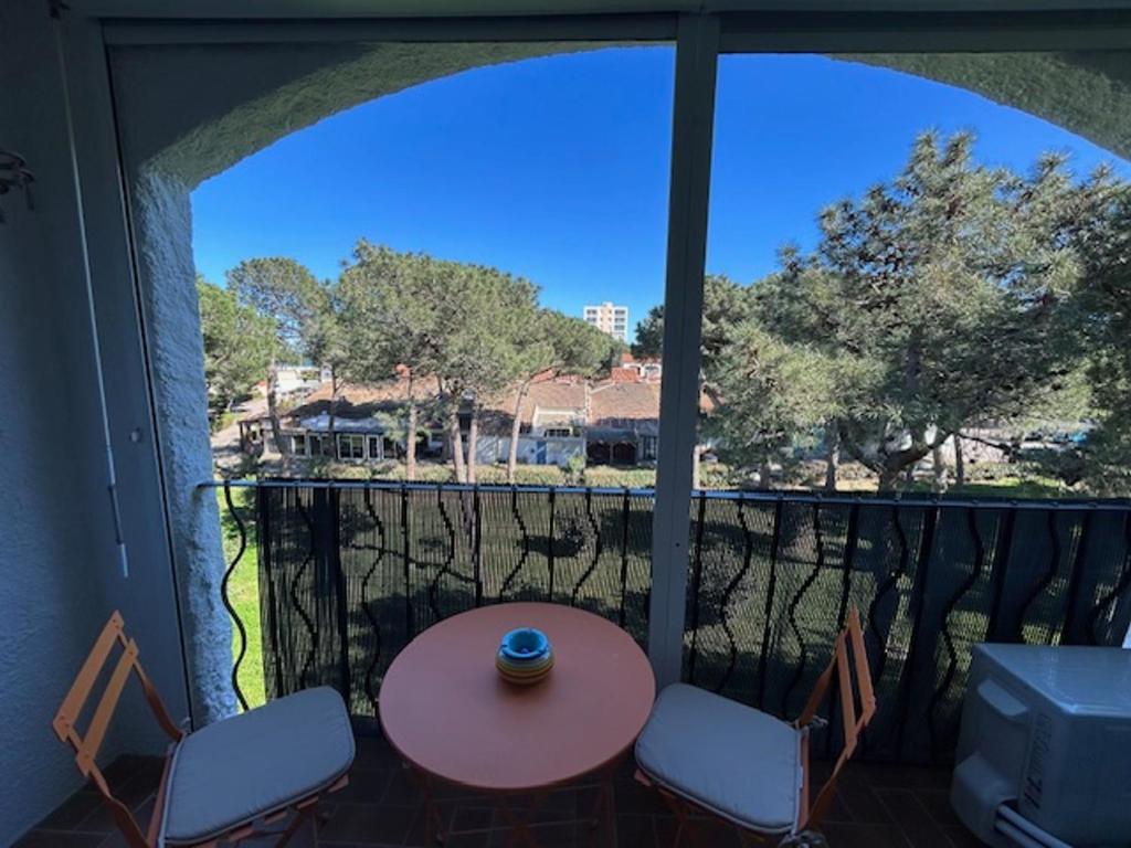 une vue d'un balcon avec une table et des chaises dans l'établissement Appartement climatisé pour 4 personnes proche plage - FR-1-837-6, à Argelès-sur-Mer