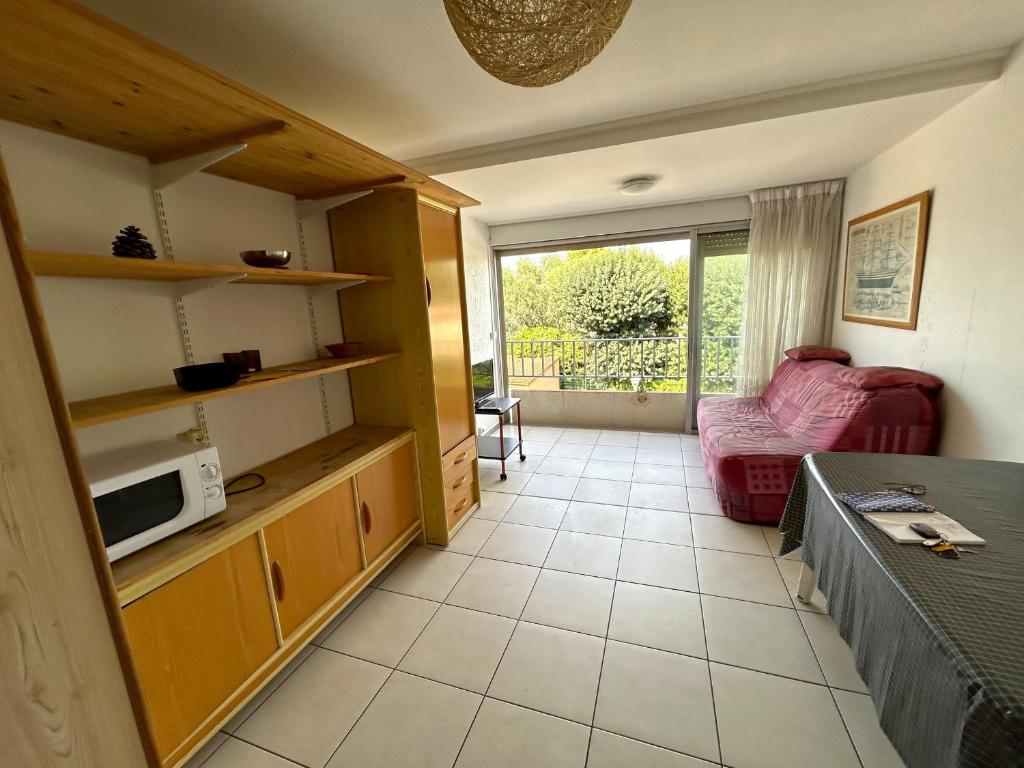 - un salon avec un canapé et un four micro-ondes dans l'établissement Appartement 4 personnes avec garage - FR-1-837-2, à Argelès-sur-Mer