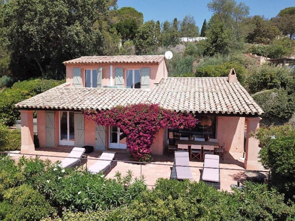 une maison avec une table et des chaises devant dans l'établissement Charmante villa 4 chambres avec jacuzzi et parking près de la plage - FR-1-726-62, à La Croix-Valmer