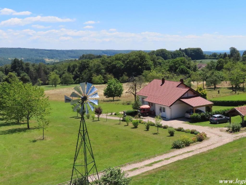 an aerial view of a house and a windmill at Charmant Gîte 4* dans un Hameau Paisible des Vosges - FR-1-583-388 in Fougerolles