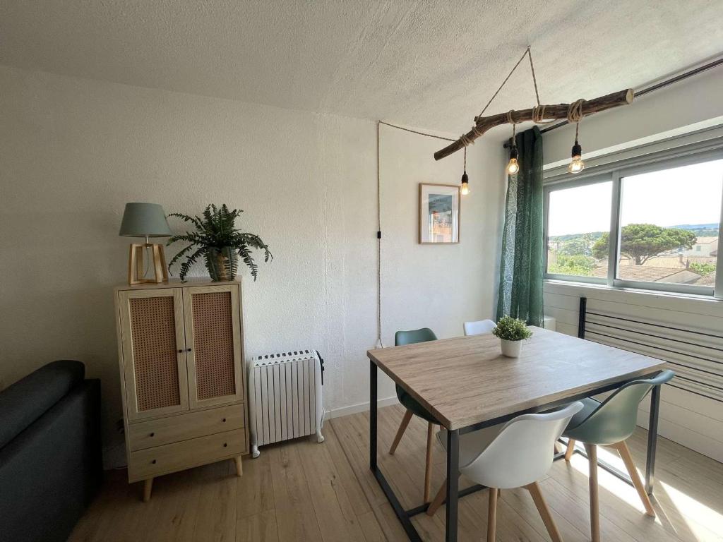un salon avec une table et des chaises et une fenêtre dans l'établissement Appartement 2 pièces, accès plage, parking privé, Narbonne Plage - FR-1-229B-111, à Narbonne