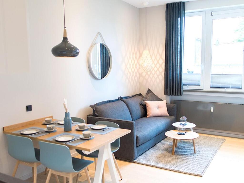 ein Wohnzimmer mit einem blauen Sofa und einem Tisch in der Unterkunft Lüttjer Kaiser Comfortable holiday residence in Norderney