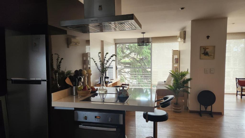 a kitchen with a counter and a stove top oven at Espectacular Departamento en Concord Pilar con cochera in La Lonja