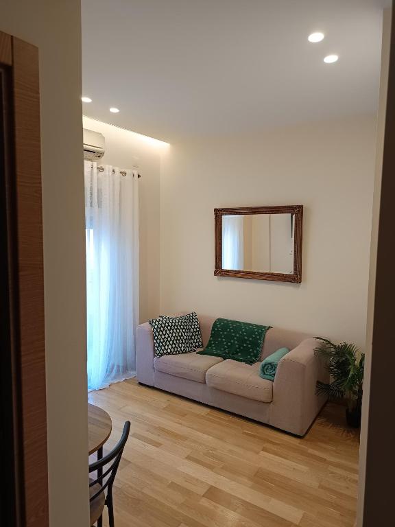 a living room with a couch and a mirror at MCR Barreiro - O Limoeiro in Lavradio