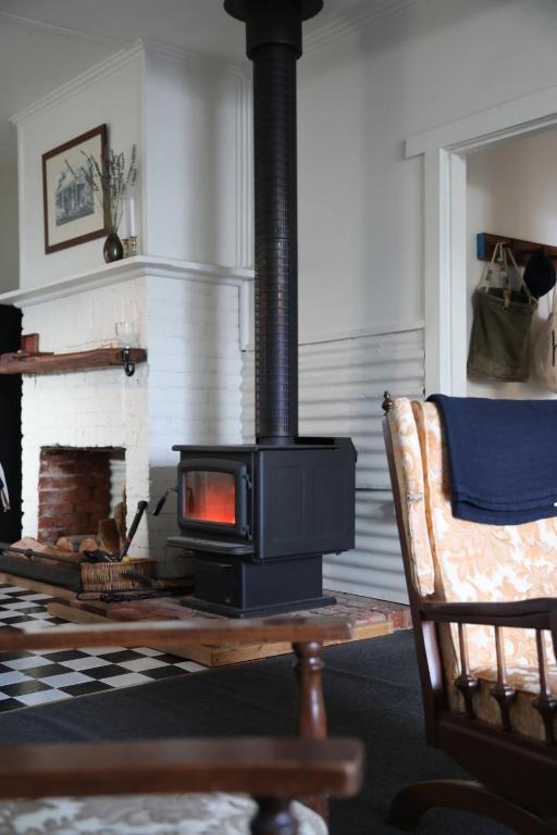 a fireplace in a living room with a stove at Homeo Alpine Cottage in Omeo