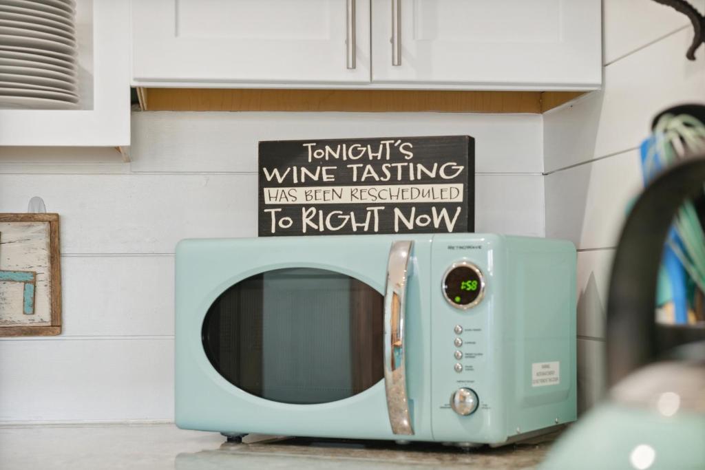 un microondas en la encimera de la cocina con un cartel en Come Sail Away, en Destin