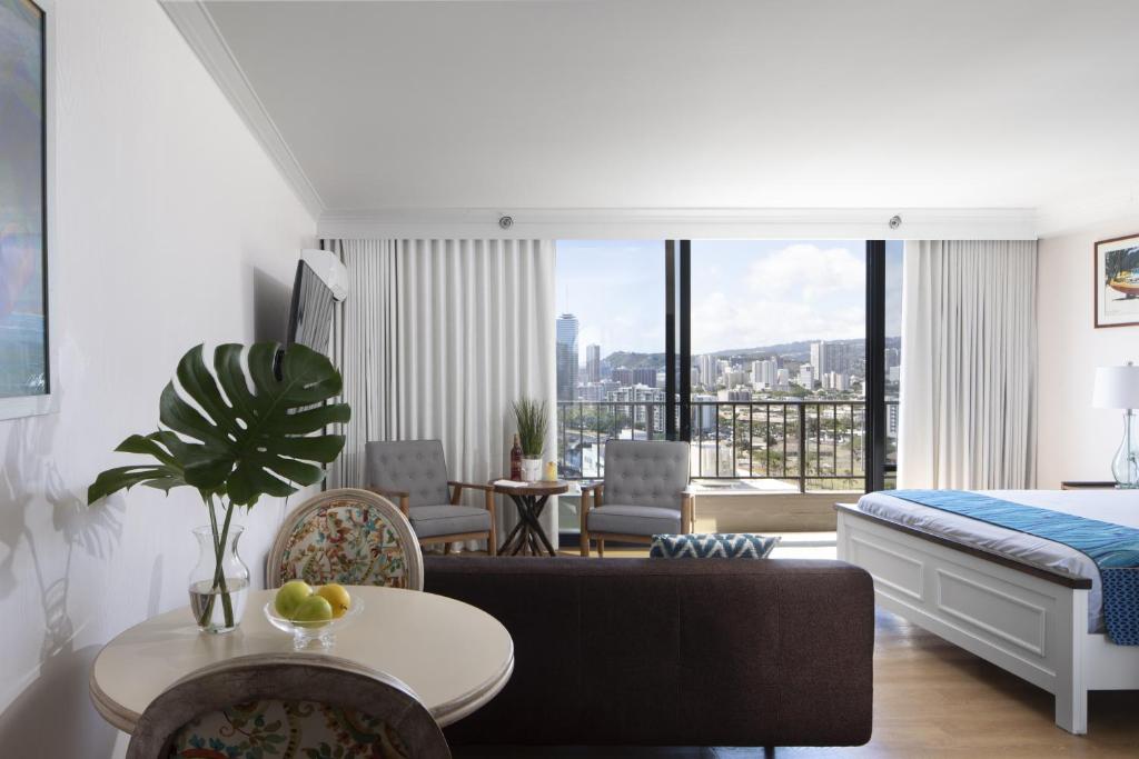 a bedroom with a bed and a living room at Refreshing Royal Garden Studio condo in Honolulu