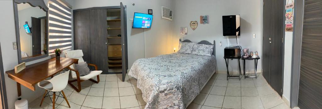 トゥストラ・グティエレスにあるVictoria Habitación Privadaのベッドと机と鏡のある寝室