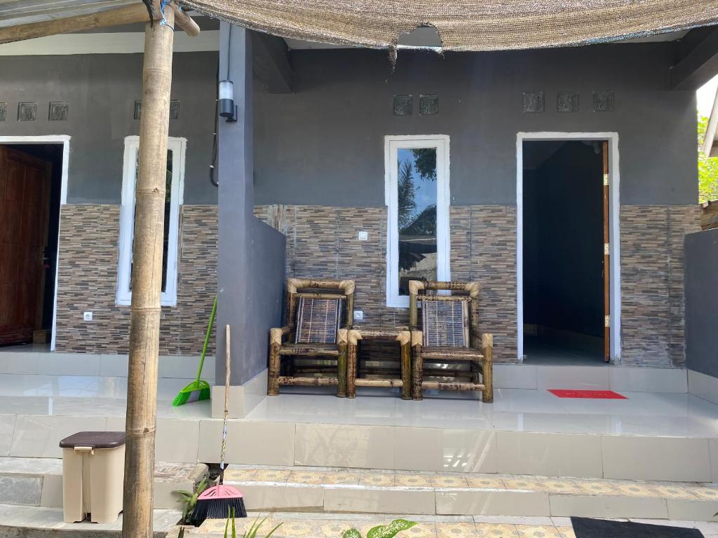 two chairs sitting on the front porch of a house at Andre Homestay in Kuta Lombok
