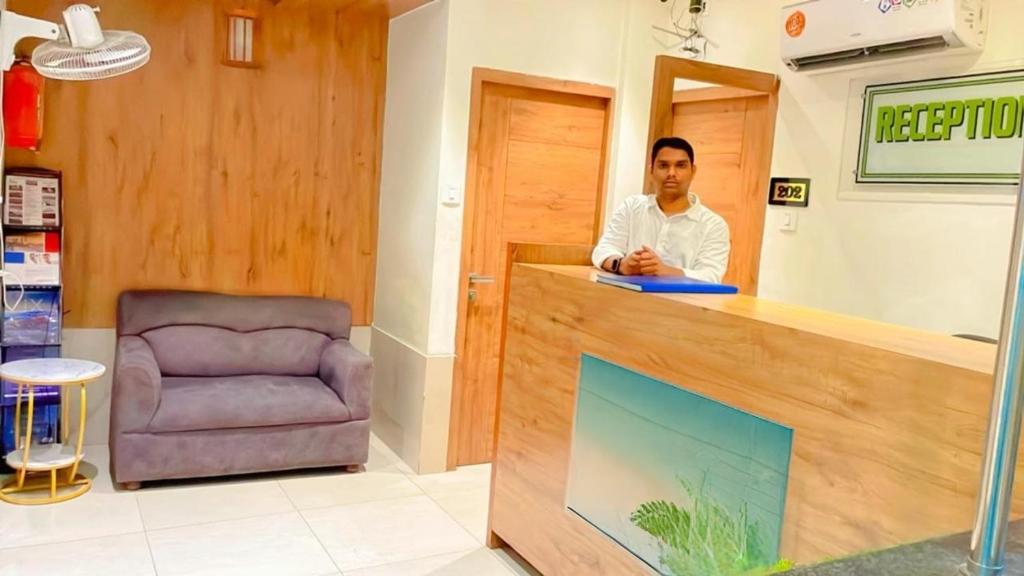 un hombre de pie en una recepción en una tienda en Hotel RR inn-International Airport, en Bombay