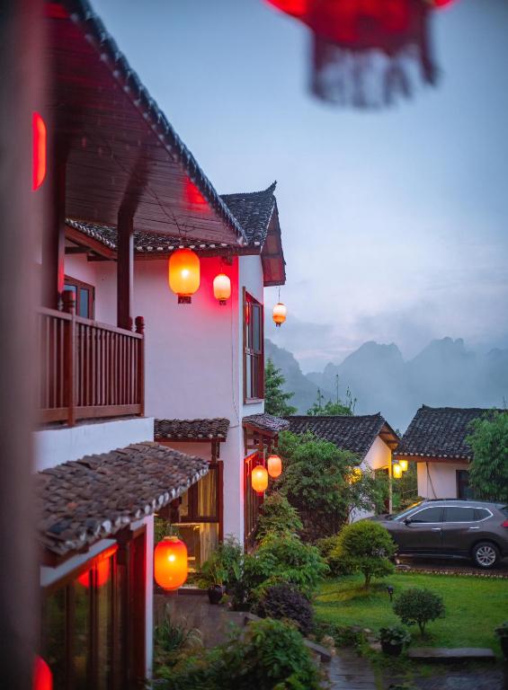 a house with orange lanterns on the side of it at Shuimu Xiaoxiang Rural Retreat Near Zhangjiajie National Forest Park With Mountain Views Authentic Chinese Village Life Quiet Nature Escapes And Local Culture For Discerning Travelers Seeking Serenity in Zhangjiajie
