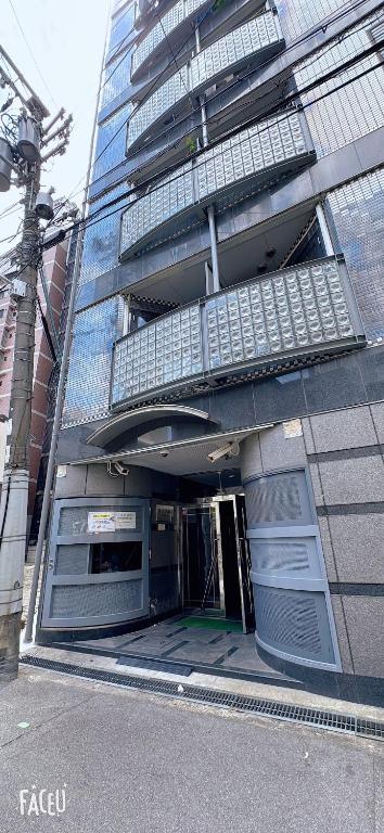 una vista exterior de un edificio con una puerta abierta en Ceci house 梅田, en Osaka