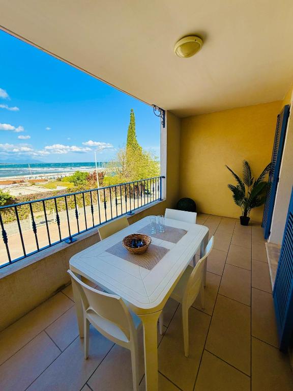 une table et des chaises sur un balcon avec vue sur l'océan dans l'établissement Appartement lumineux avec terrasse vue mer, à Sari-Solenzara