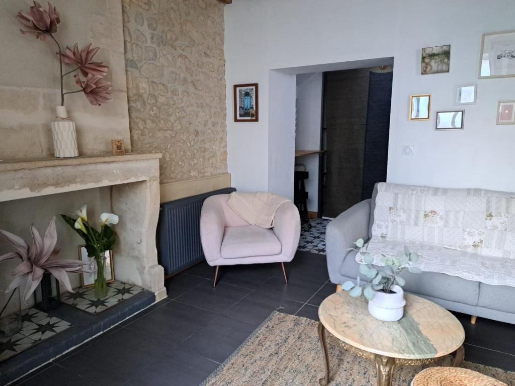 - un salon avec une cheminée et une chaise dans l'établissement La petite bajocasse, à Bayeux