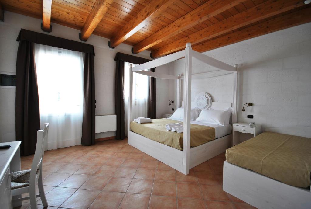 a bedroom with a canopy bed in a room at Agriturismo Tenuta Kyrios con piscina in Borgagne