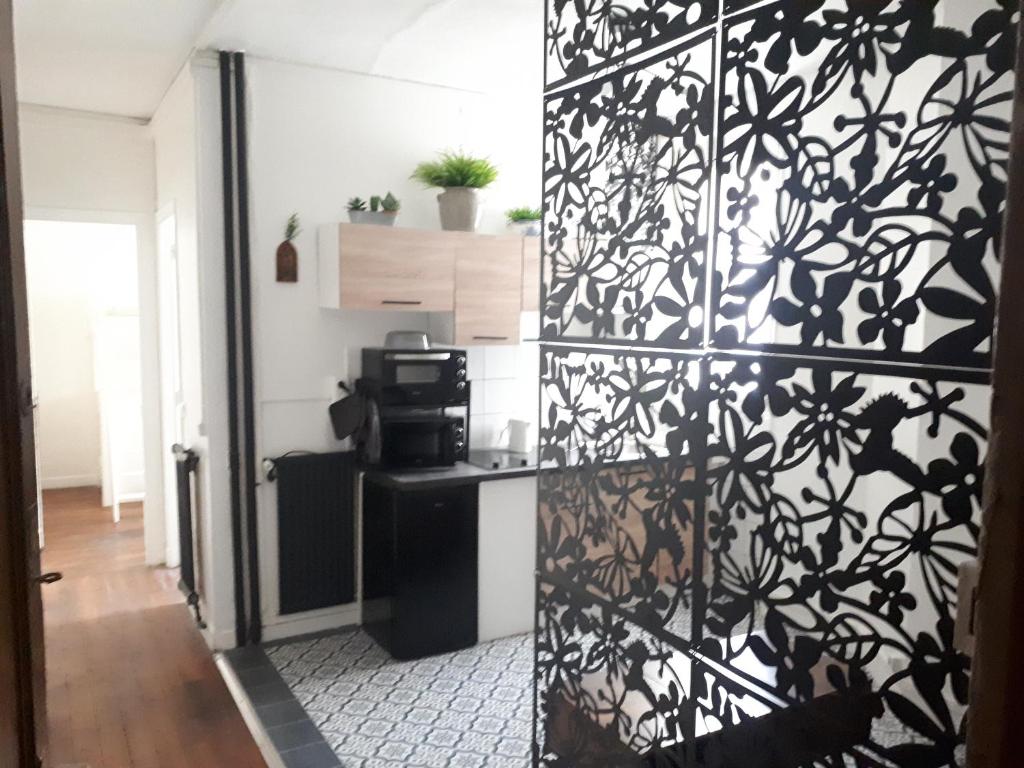 eine Küche mit einer schwarz-weiß gemusterten Wand in der Unterkunft Vincennes - Parisian appartment in Vincennes