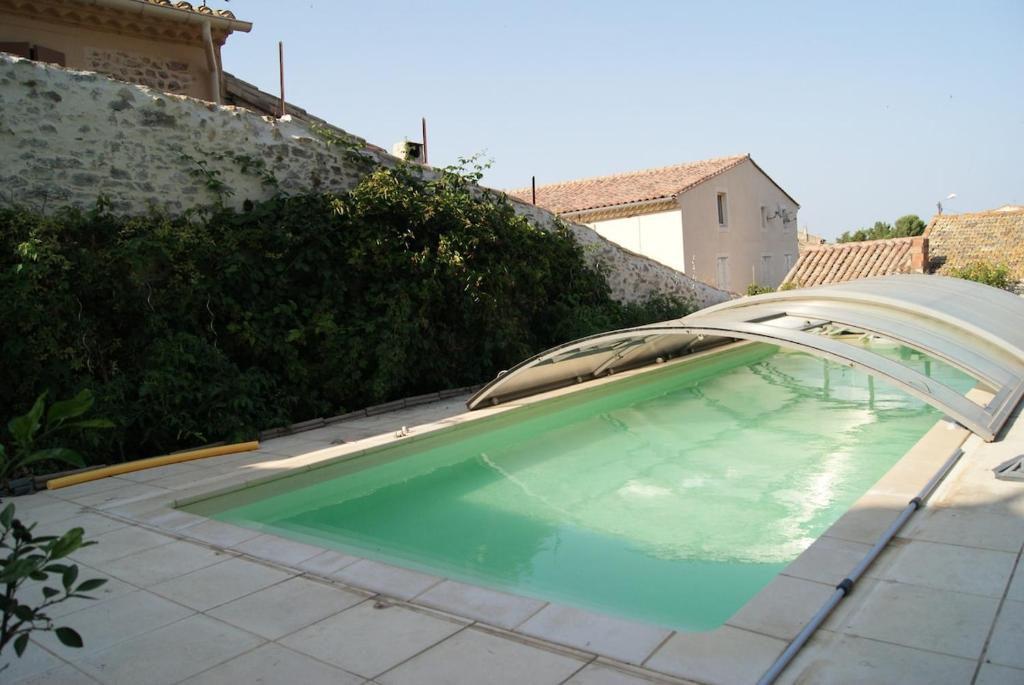 ein Swimmingpool mit Poolvisor in einem Hinterhof in der Unterkunft Gîte de la tour avec piscine entre Carcassonne et narbonne in Capendu