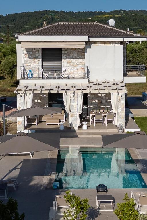 a house with a swimming pool in front of a house at Olive Residence in Skala Fourkas