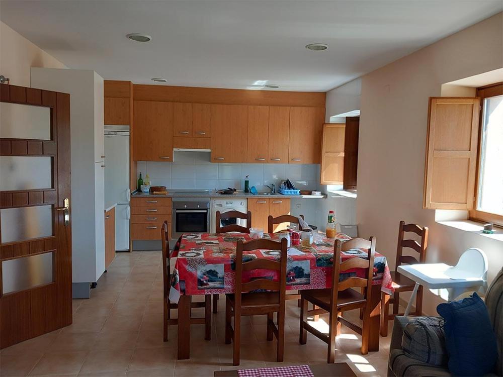 eine Küche mit einem Tisch und Stühlen sowie ein Esszimmer in der Unterkunft Apartamento Rural Dehesa de Solanillos in Mazarete