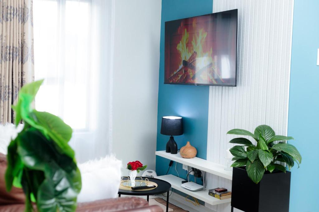 a living room with a tv on a blue wall at Stunning 1 bed in Midrand at 93 On New Estate in Midrand