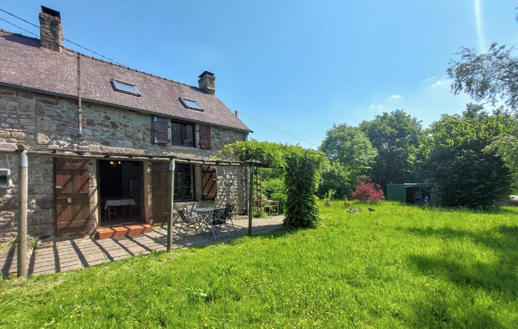 an old stone house with a large yard at Maison À La Campagne in Le Ferré