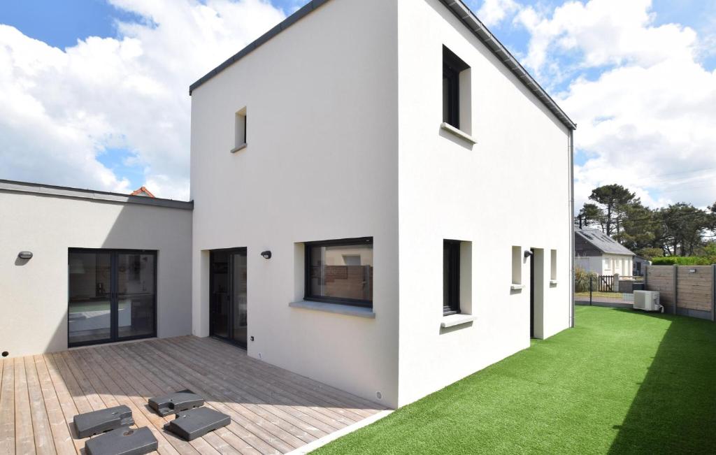 a white house with a green lawn at Maison Moderne Proche Plage in Pirou