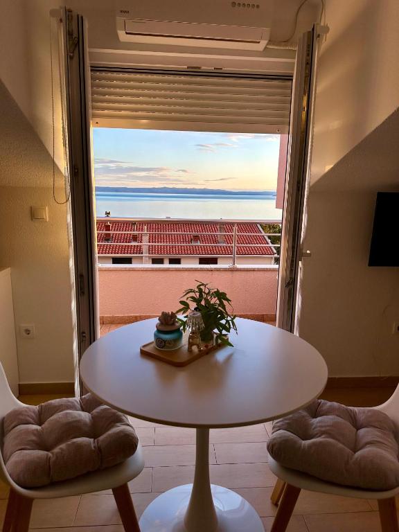 a table and chairs in a room with a large window at Sara Apartments in Makarska