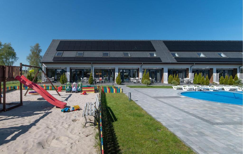 a playground with a slide in front of a building at Nice Apartment In Nowecin With Sauna in Nowecin