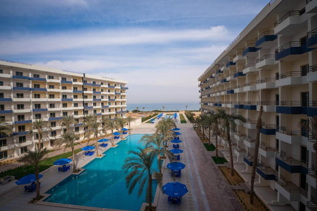 a view of a resort with a swimming pool and palm trees at Viva Coast Resort - El Galala - El Sokhna in Ain Sokhna