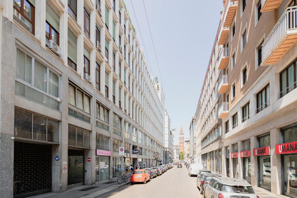 ulica miejska z zaparkowanymi samochodami i budynkami w obiekcie Magic flat in Duomo by Easylife w Mediolanie