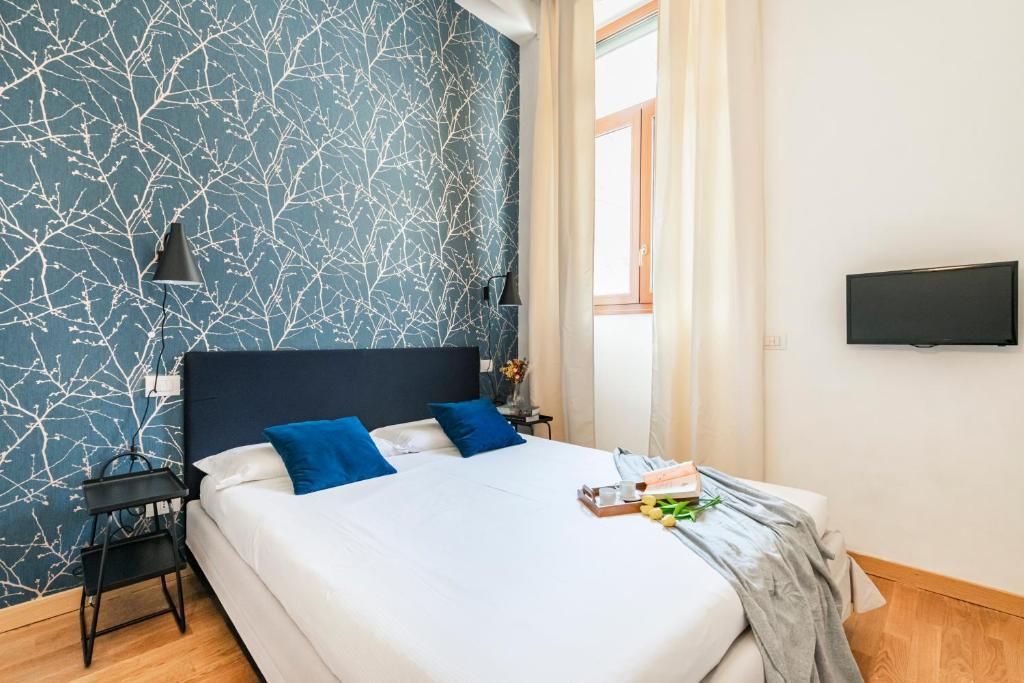 sypialnia z łóżkiem z niebiesko-białą tapetą w obiekcie Magic flat in Duomo by Easylife w Mediolanie