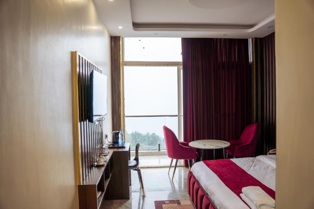 a hotel room with a bed and a table and chairs at Aroma & U in Kūfrī