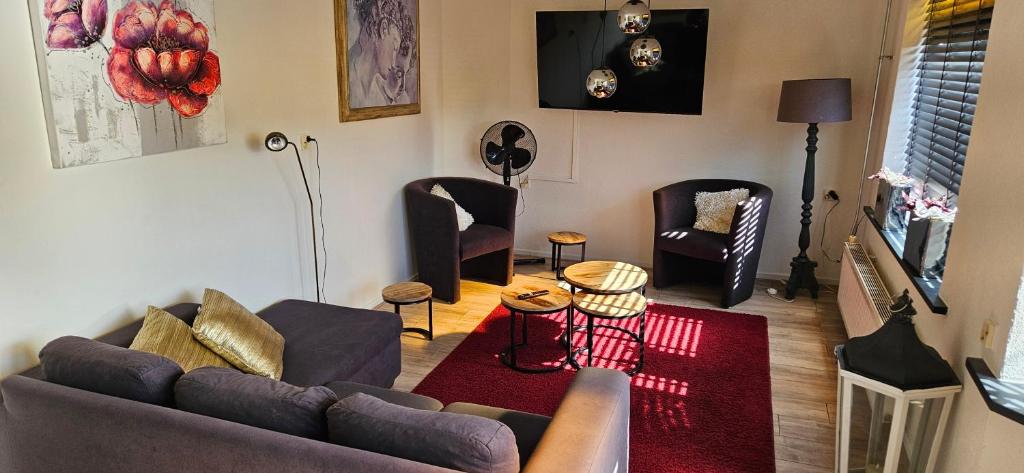 a living room with a couch and chairs and a television at Reiderland appartementen centrum Bad Nieuweschans 50 meter supermarkt in Bad-Nieuweschans