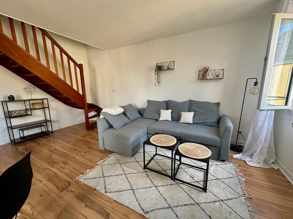 un salon avec un canapé bleu et deux tables dans l'établissement Le 203 - 4 Personnes - Gare, au Mans